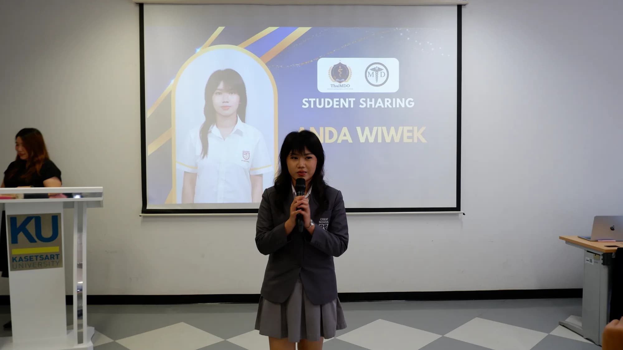 A student speaks into a microphone during the student sharing segment of the ceremony.